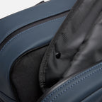 Garment duffel with interior compartments, blue exterior stitching, and durable lining for organized travel and clothing protection.