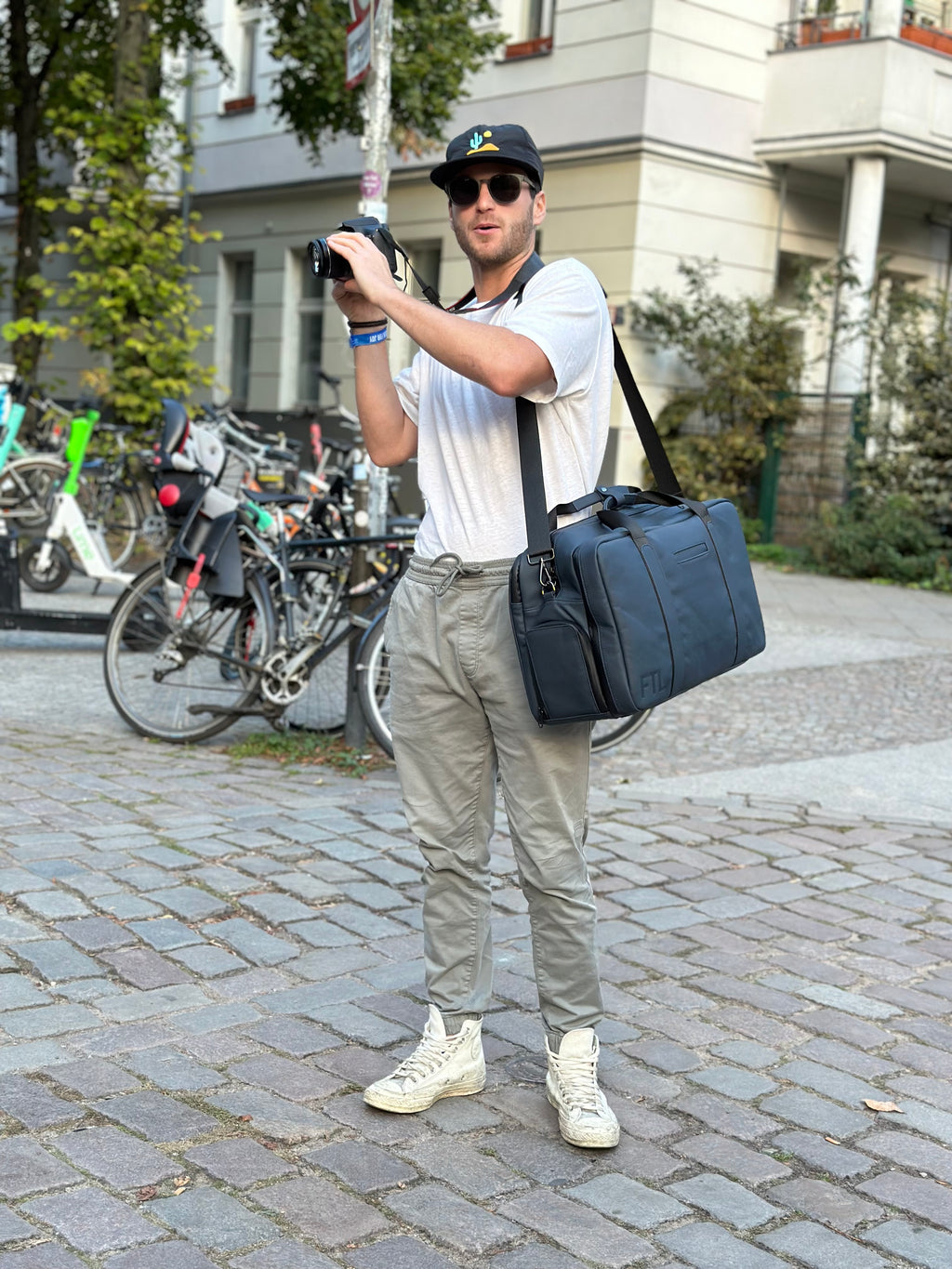 Best gym work bag with shoulder strap shown in urban setting, combining functionality and style for fitness and photography use. Essex Blue