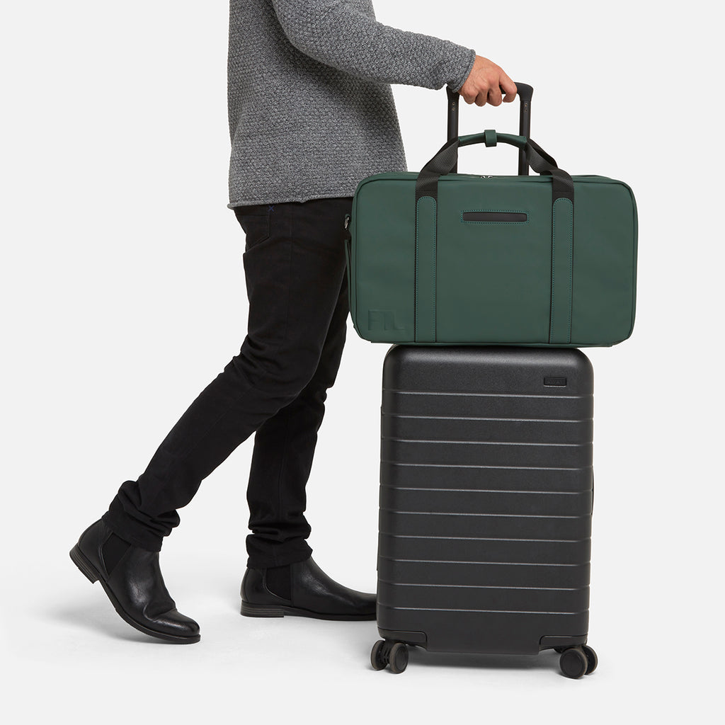 Men's duffle bag for travel in green with trolley sleeve, perfect for stylish and convenient airport or weekend trips.