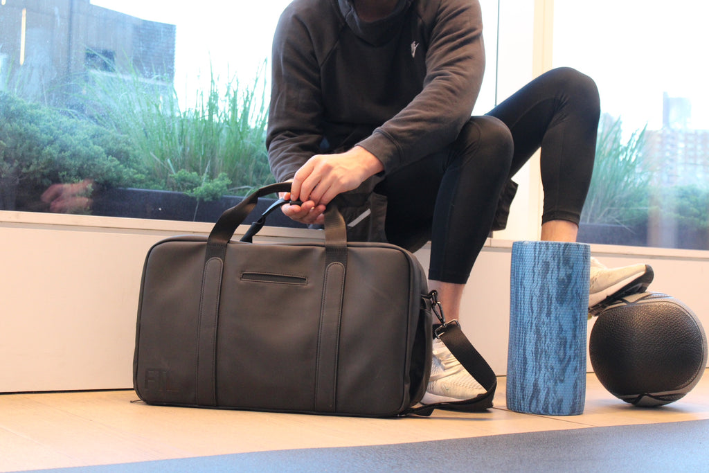 Duffle bag for work and gym in black, shown with activewear and gear, ideal for professional and fitness lifestyles.