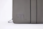 Close-up of stone grey FTL Pro duffel bag showing embossed logo and zip detail.