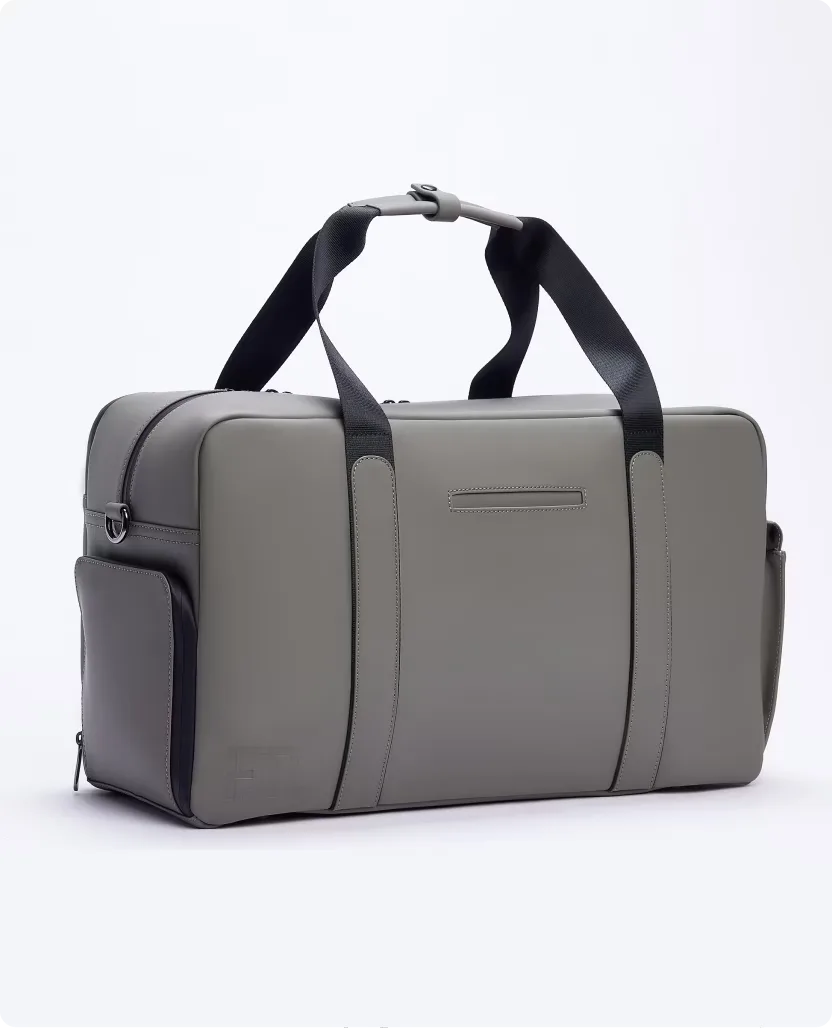 Grey FTL Lite duffel bag with black carry handles and side pocket for gym and work.