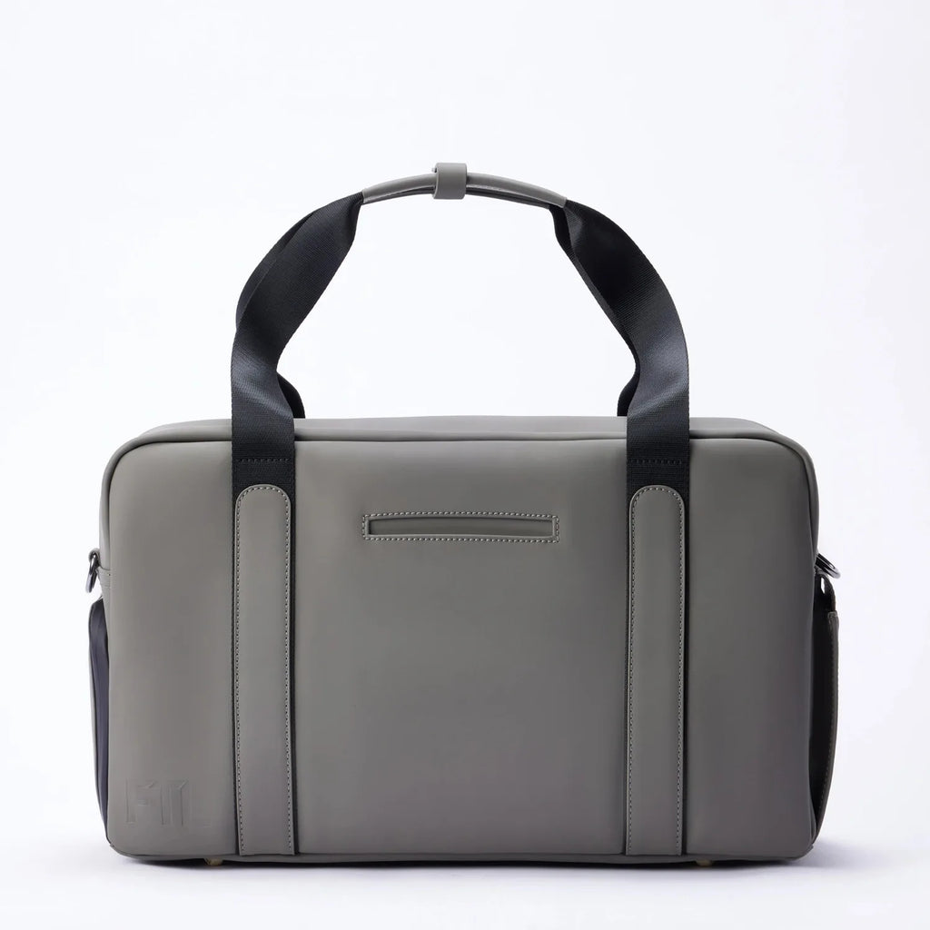 Grey FTL Lite duffel bag with black carry handles, shown front-on for gym and work.